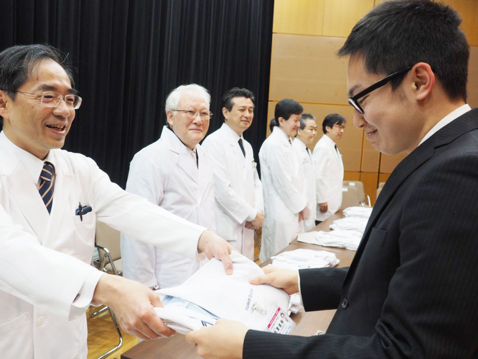 列席者から学生１人１人に白衣が手渡された。